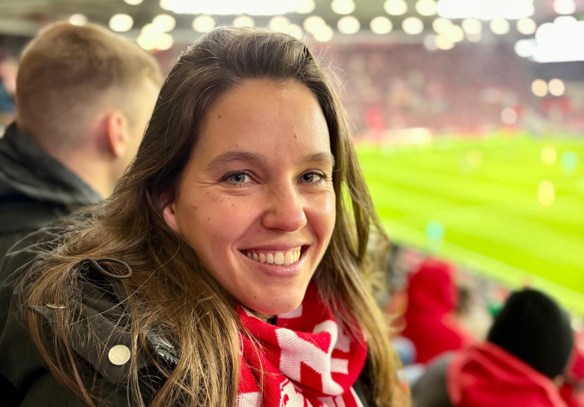 Isabell Rahms, CDU-Landtagskandidatin für Mainz, sitzt in der MEWA ARENA auf der Tribüne. Sie trägt einen rot-weißen Mainz 05 Schal und zeigt ihre Verbundenheit zur Stadt und zum Verein.