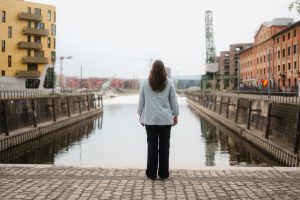 Isabell Rahms, CDU-Landtagskandidatin für Mainz, steht am Zollhafen und blickt auf das Hafenbecken. Links im Bild das goldene Gebäude Pandion DOXX, rechts das Gutenberg Digital Hub – moderne Architektur trifft Mainzer Lebensgefühl.
