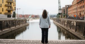 Isabell Rahms, CDU-Landtagskandidatin für Mainz, steht am Zollhafen und blickt auf das Hafenbecken. Links im Bild das goldene Gebäude Pandion DOXX, rechts das Gutenberg Digital Hub – moderne Architektur trifft Mainzer Lebensgefühl.