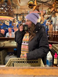 Isabell Rahms am Glühweinstand von Marco Sottile vor den Markthäusern auf dem historischen Weihnachtsmarkt Mainz, mit Tasse Glühwein in der Hand
